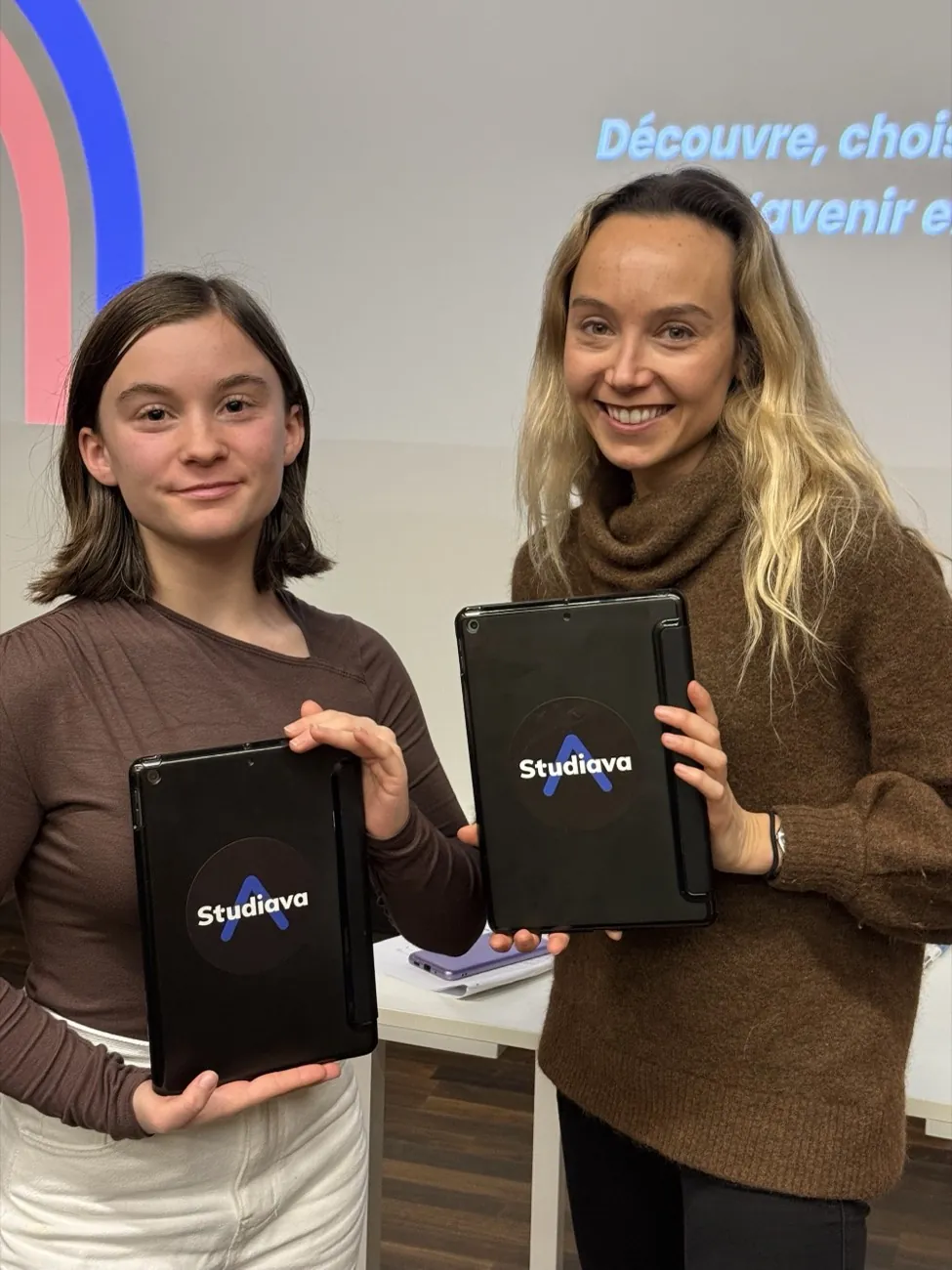 Une collégienne et une animatrice StudiAva posent avec des tablettes StudiAva.